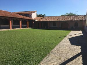 une cour herbeuse avec deux maisons et un bâtiment dans l'établissement CASARÃO CAPITAL DO SURF SAQUAREMA, à Saquarema