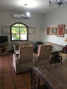- un salon avec un canapé, des chaises et une table dans l'établissement CASARÃO CAPITAL DO SURF SAQUAREMA, à Saquarema