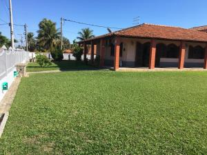 une cour d'une maison avec une grande pelouse dans l'établissement CASARÃO CAPITAL DO SURF SAQUAREMA, à Saquarema