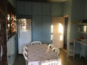 La cuisine est équipée d'une table, de chaises et d'un réfrigérateur. dans l'établissement CASARÃO CAPITAL DO SURF SAQUAREMA, à Saquarema