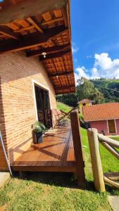 una terraza de madera en el lateral de una casa en Chalé Sonho Diniz 2, en Monte Verde