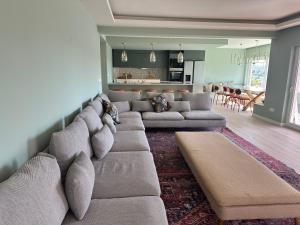 a living room with a large couch and a kitchen at Retreat Villa, 17m to Downtown, up to 29ppl in Lisbon