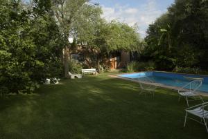 コルドバにあるCasa de Flores, Agua y Musicaの椅子とベンチのあるプールのある庭