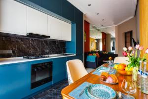 Una cocina con gabinetes azules y una mesa de madera. en 107 LUXURY APARTMENT in AC KAZAKHSTAN, Minor area, Amir Timur Avenue, en Tashkent