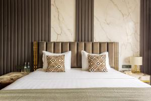 una habitación con una cama grande con sábanas y almohadas blancas en 107 LUXURY APARTMENT in AC KAZAKHSTAN, Minor area, Amir Timur Avenue, en Tashkent