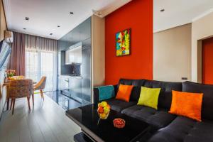 Una sala de estar con un sofá negro y una pared naranja en 107 LUXURY APARTMENT in AC KAZAKHSTAN, Minor area, Amir Timur Avenue, en Tashkent
