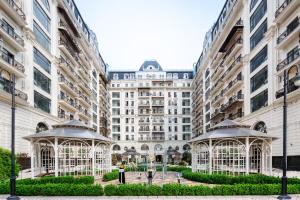 Un gran edificio con dos cenadores en un patio. en 107 LUXURY APARTMENT in AC KAZAKHSTAN, Minor area, Amir Timur Avenue, en Tashkent