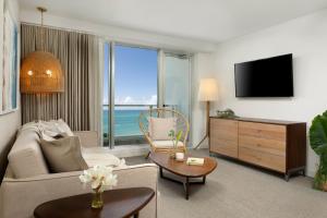 uma sala de estar com um sofá e uma televisão em Casa Costera, Isla Verde Beach, Apartments by Marriott Bonvoy em San Juan