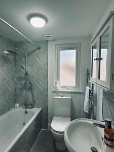 Deluxe Bungalow في Longham: حمام مع حوض ومرحاض ومغسلة