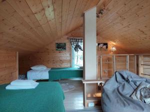 a room with two beds in a wooden cabin at Przystanek Trześcianka in Trześcianka