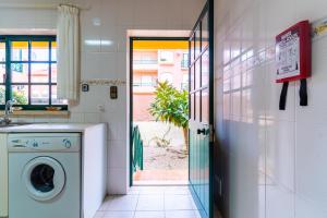 una lavandería con lavadora y secadora junto a una puerta en Beach House Villa At Peniche - Praia Consolação, en Atouguia da Baleia