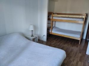 1 Schlafzimmer mit 2 Etagenbetten und einer Lampe in der Unterkunft Le Cottage in Donnery