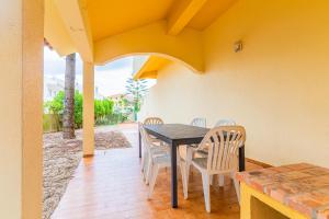 a dining room with a table and chairs on a patio at Beach House Villa At Peniche - Praia Consolação in Atouguia da Baleia