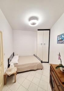 ein weißes Schlafzimmer mit einem Bett und einem Schrank in der Unterkunft Maria's urban seaview apartments in Iraklio