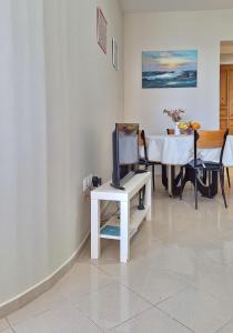 ein Wohnzimmer mit einem TV auf einem weißen Tisch in der Unterkunft Maria's urban seaview apartments in Iraklio