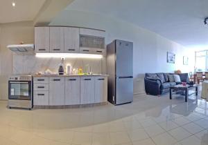 eine Küche mit einem Kühlschrank aus Edelstahl im Wohnzimmer in der Unterkunft Maria's urban seaview apartments in Iraklio