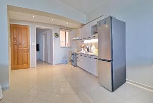 eine große Küche mit einem Kühlschrank aus Edelstahl in der Unterkunft Maria's urban seaview apartments in Iraklio