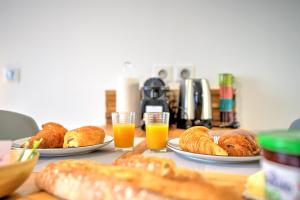 Le Déroc - Netflix Wi-Fi Fibre Terrasse في Banassac: طاولة مع أطباق من الحلويات وأكواب عصير البرتقال