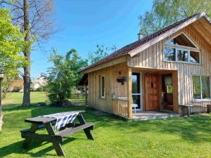 a wooden cabin with a picnic table in front of it at Przystanek Trześcianka in Trześcianka