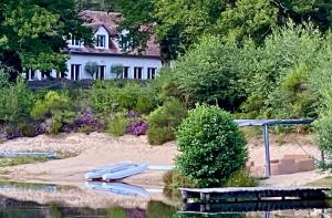 una casa sentada en la orilla de un cuerpo de agua en 'Hotel One Suite' Suite with Private Beach, Natural Swimming Pool & Reserve en Neung-sur-Beuvron
