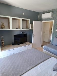 a bedroom with a bed and a flat screen tv at Studio apartman Marija in Trogir