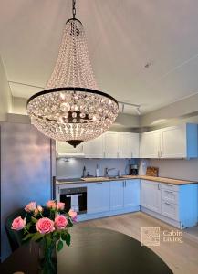 a large chandelier in a kitchen with blue cabinets at Beachfront apartment Sørenga Oslo in Oslo