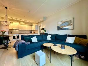 a living room with a blue couch and a table at Beachfront apartment Sørenga Oslo in Oslo