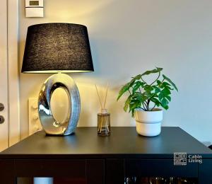 a lamp and a potted plant on a table at Beachfront apartment Sørenga Oslo in Oslo