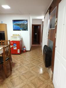 casa a una cuadra del centrode ushuaia في أوشوايا: ممر غرفة مع طاولة وميكروويف