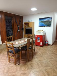 eine Küche mit einem Tisch, Stühlen und einer Mikrowelle in der Unterkunft casa a una cuadra del centrode ushuaia in Ushuaia
