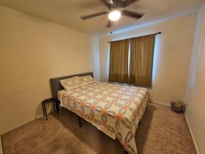 a bedroom with a bed and a ceiling fan at Chandler Charming Home in Chandler