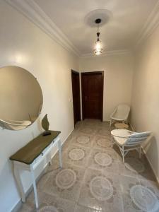 Zimmer mit einem Tisch, einem Spiegel und einem Stuhl in der Unterkunft Lina’s house in Martil