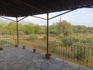 a screened in porch with a fence and potted plants at Hope's House in Platanitis