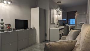 ドモドッソラにあるLA VIA DEL SALEのリビングルーム(ソファ、テレビ付)、キッチン