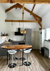 una cocina con mesa de madera y taburetes de bar en The Smiling Buddha en Achthuizen