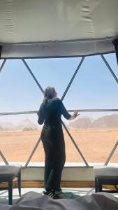 a woman looking out of a window at the desert at Rum Green Camp in Wadi Rum +93 photos