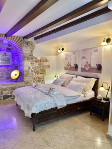 1 dormitorio con 1 cama grande y pared de piedra en Diocletian Wine studio apartment en Split