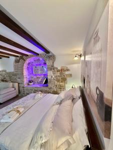 Cama en habitación con pared de piedra en Diocletian Wine studio apartment en Split