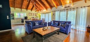 ein Wohnzimmer mit blauen Sofas und einem Holztisch in der Unterkunft Tipani Lodge - Free and Unlimited Wifi in Rarotonga