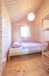 Cama en habitación de madera con ventana en Morska Polana, en Mielno