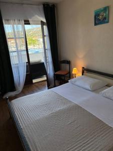 Un dormitorio con una gran cama blanca y una ventana en Villa Samac, en Trogir