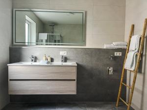 a bathroom with a sink and a mirror at Schlüssel Apartments in Lahr