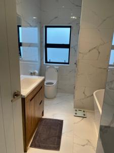 a bathroom with a sink toilet and a window at 11 A Addison street home stay - room 2 in Auckland