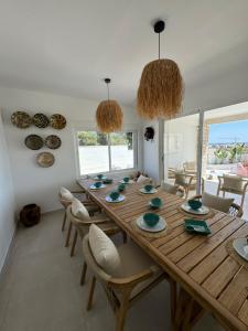 a dining room with a long wooden table and chairs at Beach house La Marina in La Marina