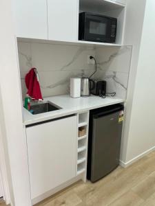 a small kitchen with a sink and a microwave at 11 A Addison street home stay - room 2 in Auckland