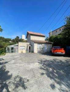 a house with a car parked in a parking lot at Les milles feuilles in Marseille