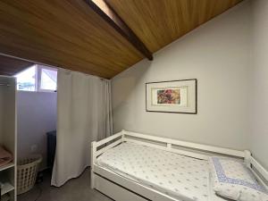 ein kleines Schlafzimmer mit einem Bett und einem Fenster in der Unterkunft Arara Azul in Florianópolis