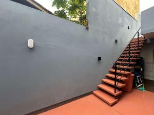 eine Treppe an der Seite eines Gebäudes mit einer Wand in der Unterkunft Arara Azul in Florianópolis