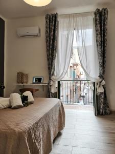 una camera da letto con un letto e una finestra con balcone di Ovidio home a Palermo
