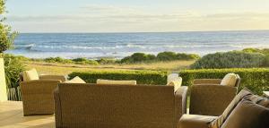 un patio con sillas y vistas al océano en Seapearl Oceanfront Villa and Cottage en Hermanus